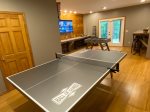 Game room with granite bar tops, barstools, 65 smart TV streaming only, ping pong table, foosball table, board games and access to back patio/yard